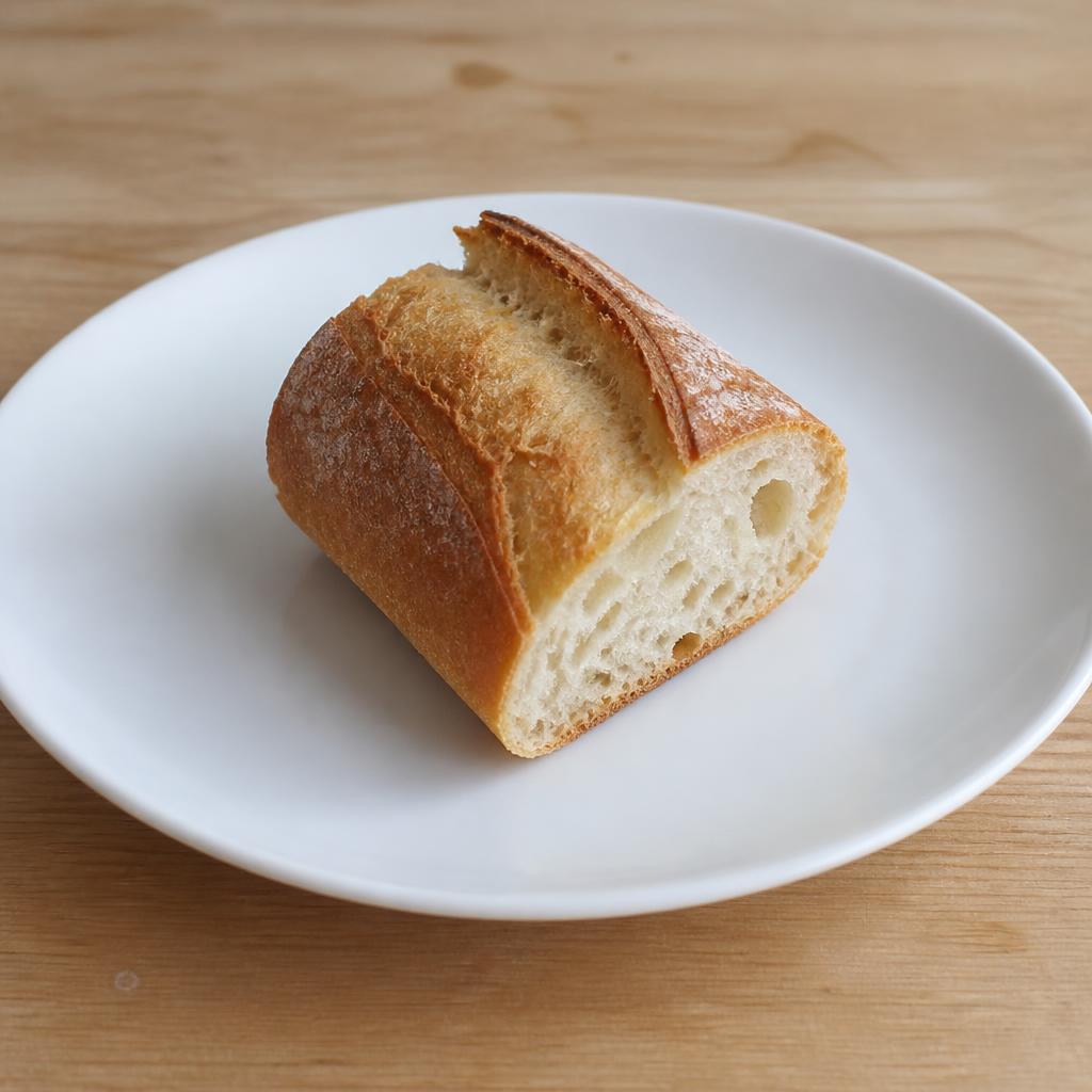 Tronçon de baguette de 80 g sur une assiette blanche